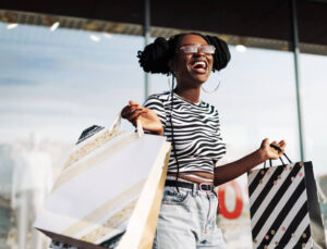A happy young woman carrying shopping bags, enjoying the incentives of a great shopping experience.